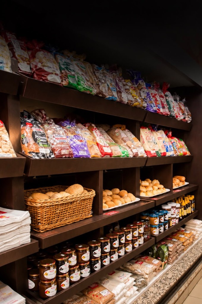 Prateleiras de padaria com pães, doces embalados e produtos da loja
